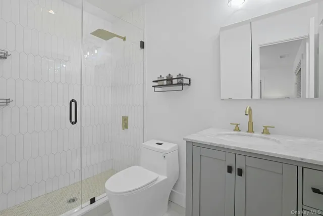 a bathroom with a toilet a sink a shower and mirror