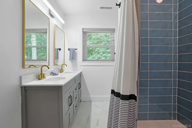 a bathroom with a sink a toilet a window and vanity