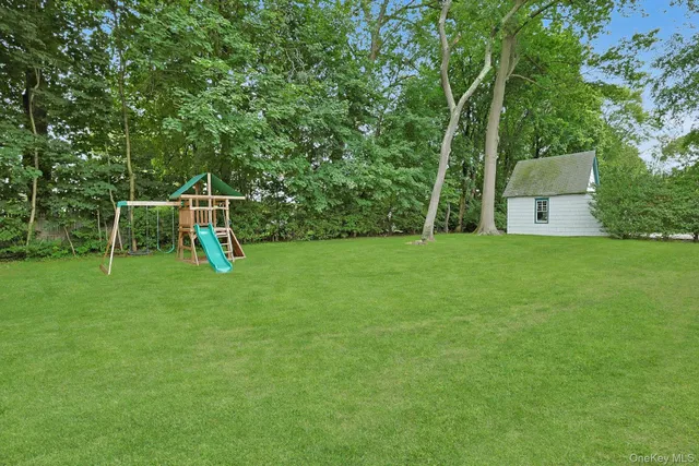 a view of a backyard with a bench and a tree
