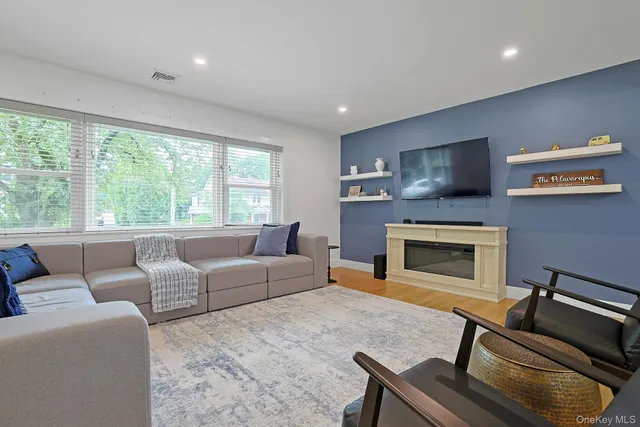 a living room with furniture a flat screen tv and a fireplace