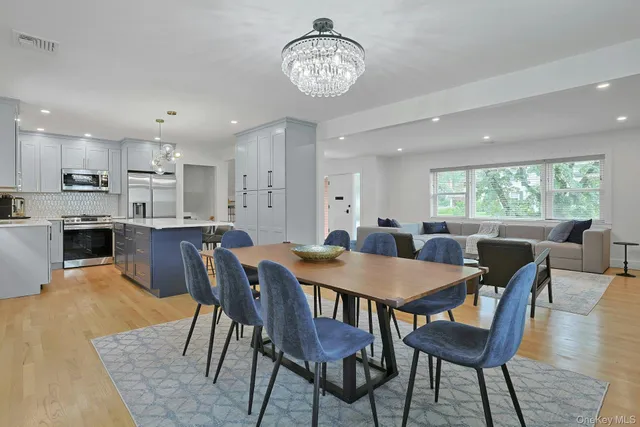 a view of a dining room with furniture a chandelier and wooden floor