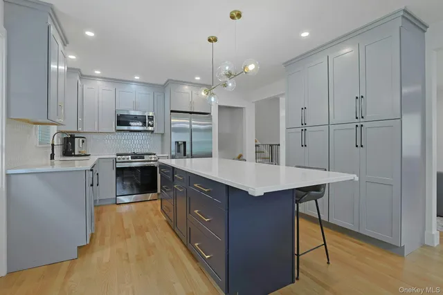 a kitchen with kitchen island stainless steel appliances a sink stove and refrigerator