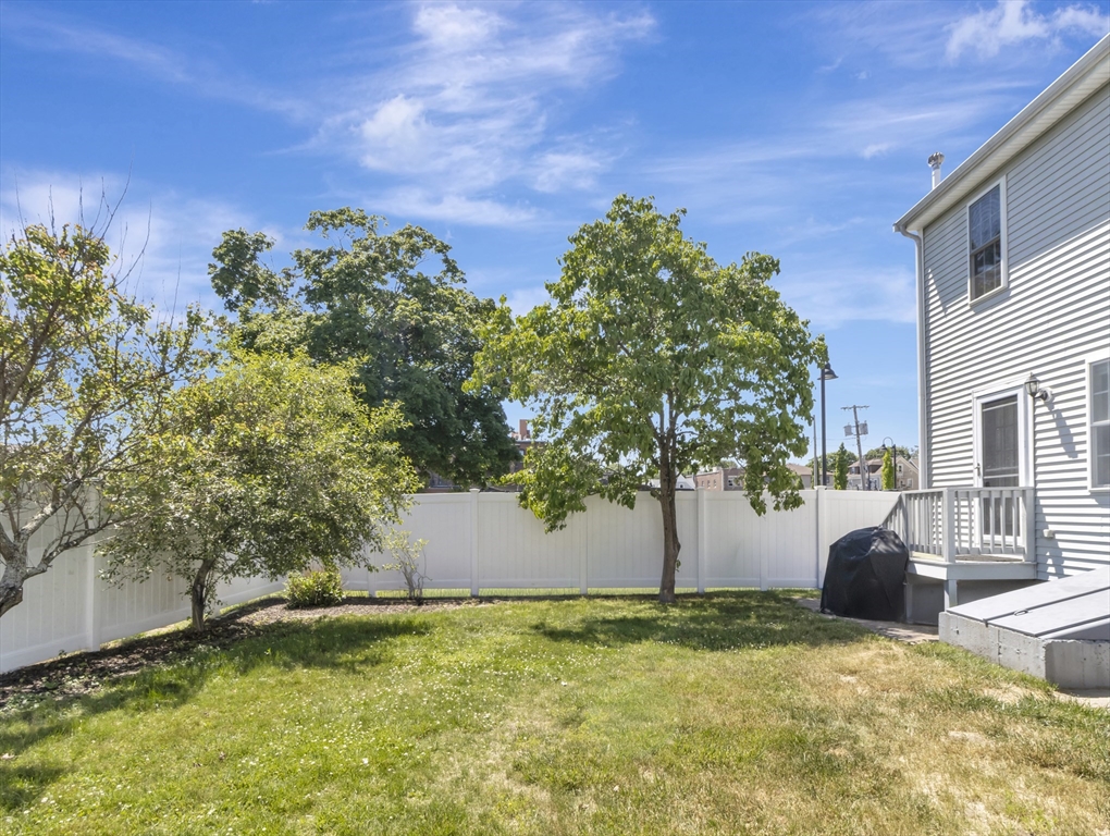 13 Shawmut Avenue, Unit 13 Mansfield, MA 02048 - Photo 28 of 34 a backyard of a house with a yard and tree