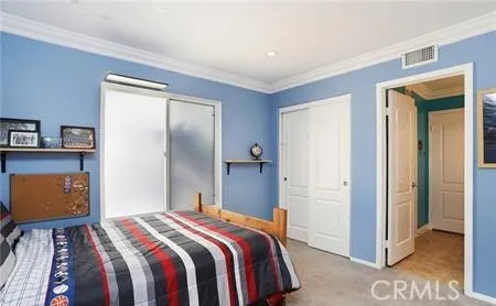 a bedroom with a bed and a painting on the wall