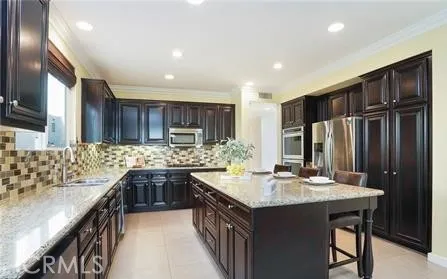 a kitchen with kitchen island granite countertop a sink stove and refrigerator