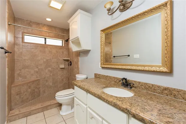a bathroom with a granite countertop sink toilet and shower