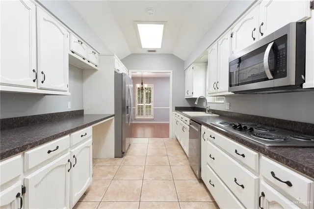 a kitchen with stainless steel appliances granite countertop a stove a sink and a microwave