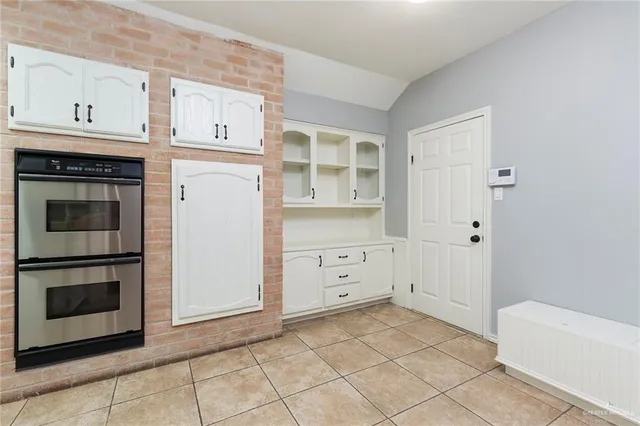 a kitchen with white cabinets and a stove