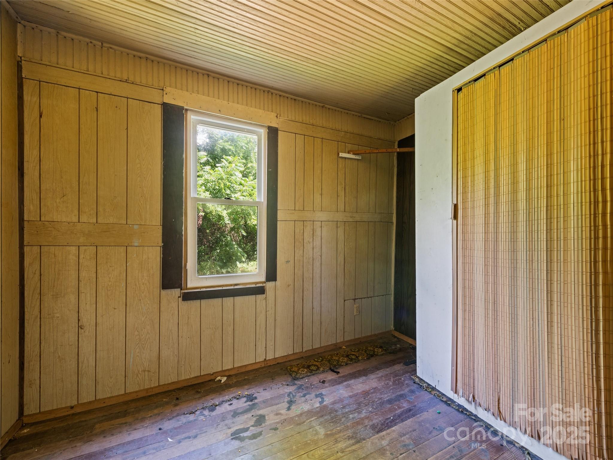 55 Shook Street Clyde, NC 28721 - Photo 18 of 21 a view of an empty room with wooden floor and a window
