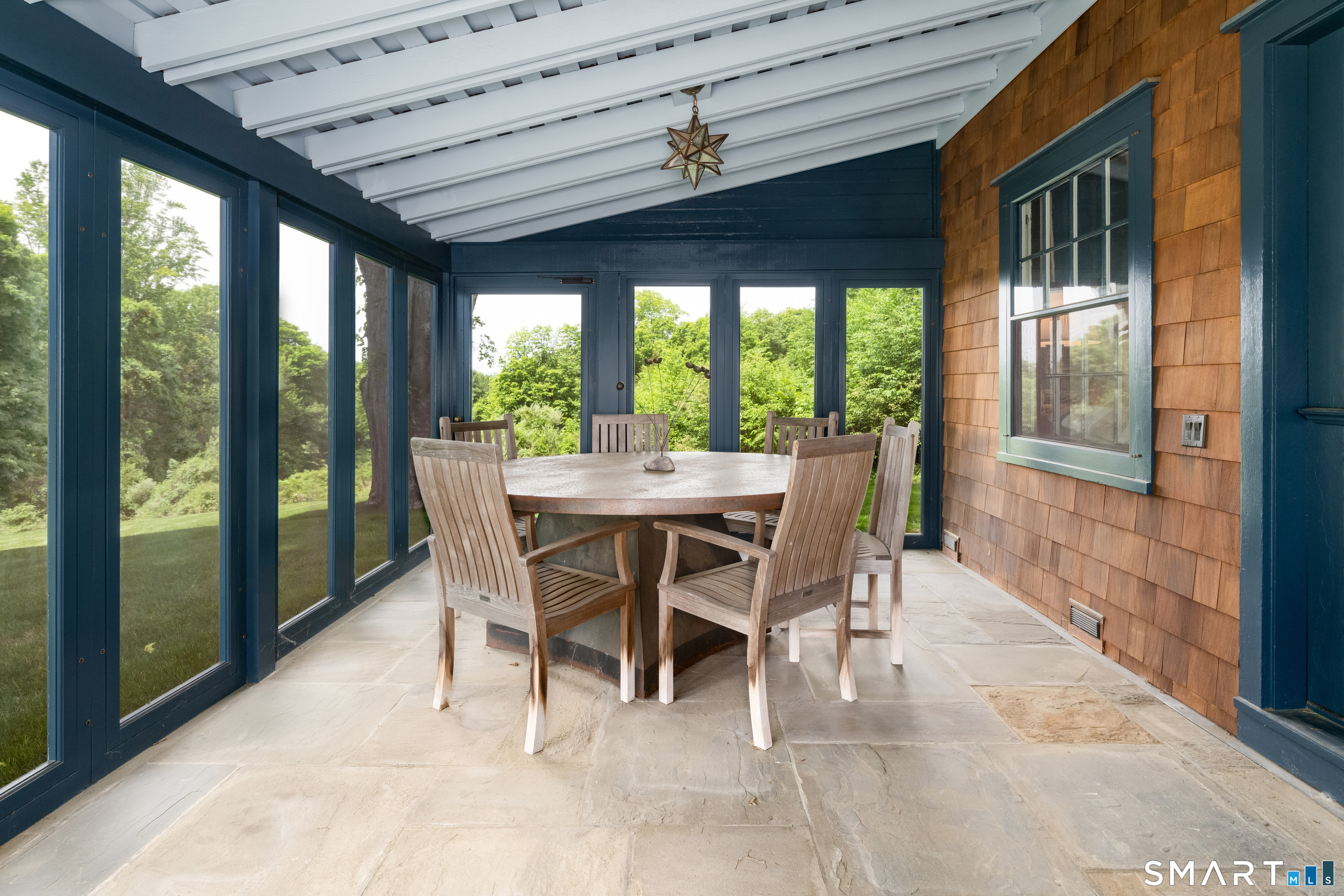 240 Umpawaug Road Redding, CT 06896 - Photo 32 of 40 The screened porch with stone flooring, sloped roof with beams, floor to ceiling screened windows around and direct access to/from the great room. Perfect living/entertaining flow.