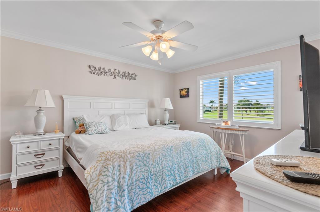 37 High Point Circle East, Unit 210 Naples, FL 34103 - Photo 12 of 29 a bedroom with a bed and a window with wooden floor