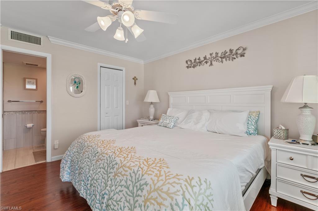 37 High Point Circle East, Unit 210 Naples, FL 34103 - Photo 13 of 29 a bedroom with a bed and wooden floor