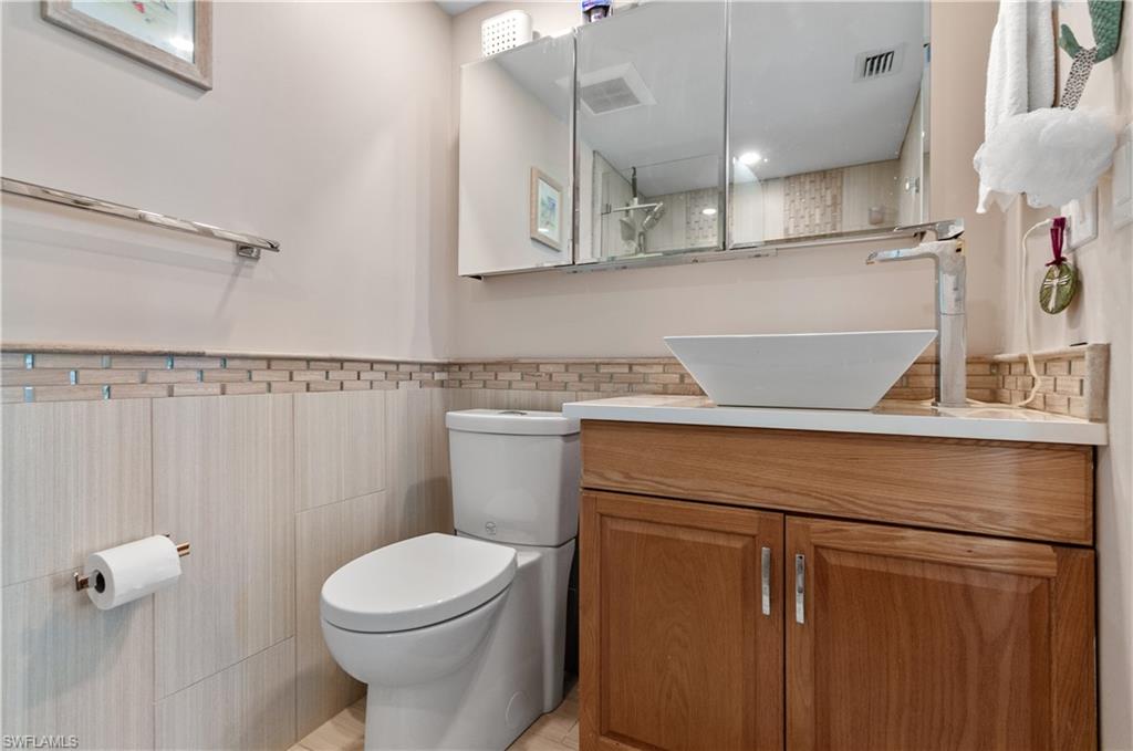 37 High Point Circle East, Unit 210 Naples, FL 34103 - Photo 15 of 29 a bathroom with a toilet sink and mirror