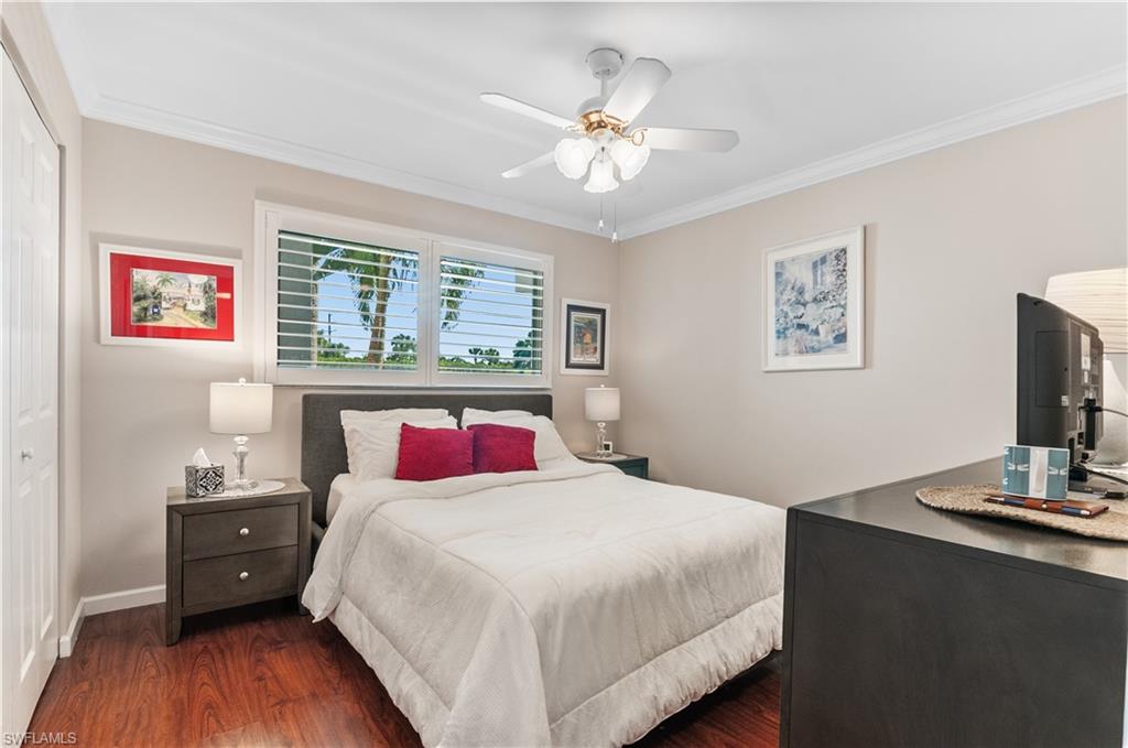 37 High Point Circle East, Unit 210 Naples, FL 34103 - Photo 17 of 29 a bedroom with a large bed and a flat tv screen on dresser