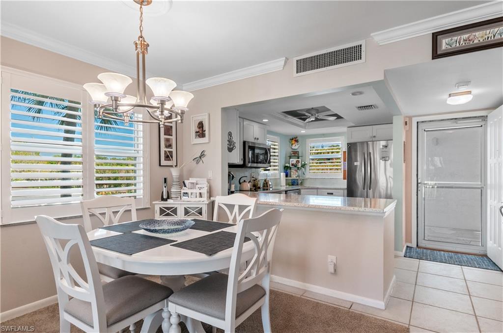37 High Point Circle East, Unit 210 Naples, FL 34103 - Photo 2 of 29 a dining room filled chandelier and kitchen view