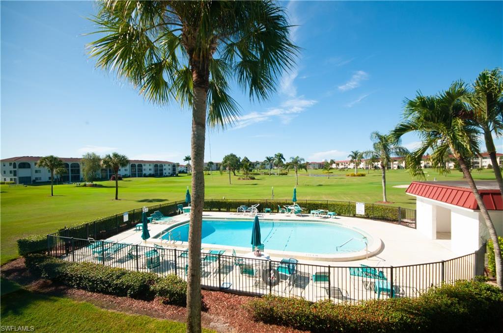 37 High Point Circle East, Unit 210 Naples, FL 34103 - Photo 22 of 29 a view of a house with a swimming pool and a yard