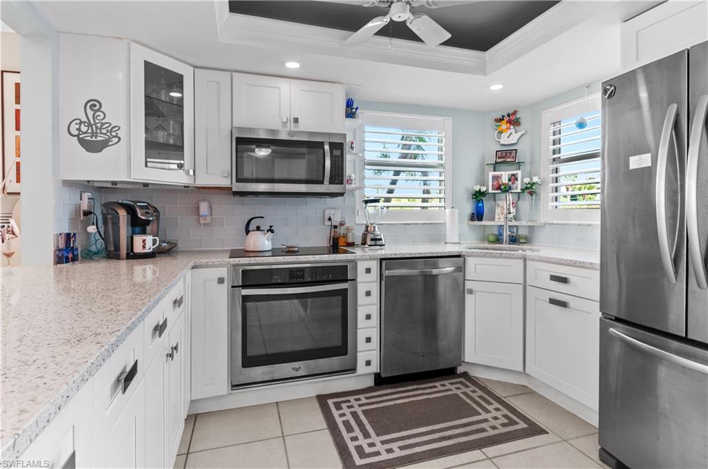 37 High Point Circle East, Unit 210 Naples, FL 34103 - Photo 5 of 29 a kitchen with stainless steel appliances a refrigerator sink and microwave