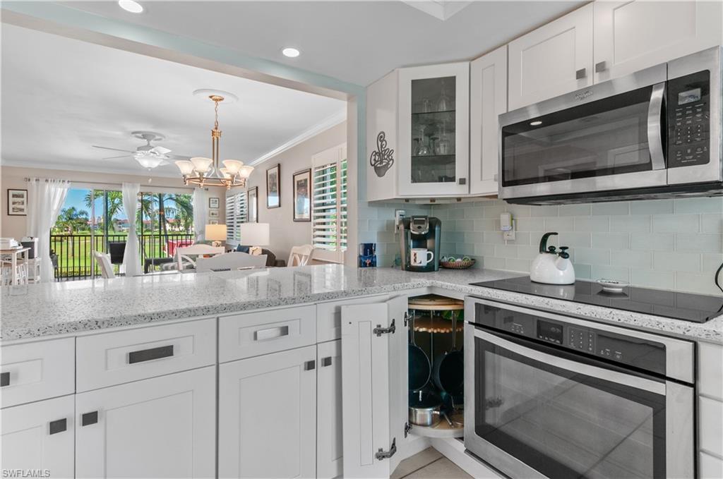 37 High Point Circle East, Unit 210 Naples, FL 34103 - Photo 6 of 29 a kitchen with stainless steel appliances granite countertop a sink stove and microwave