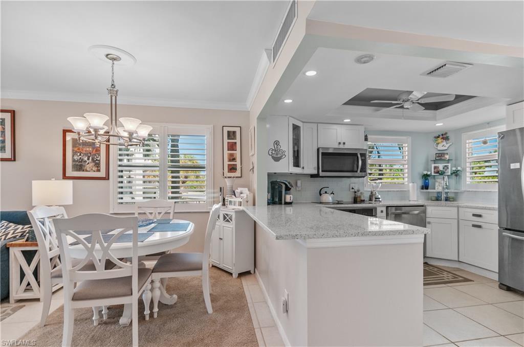 37 High Point Circle East, Unit 210 Naples, FL 34103 - Photo 7 of 29 a kitchen that has cabinets a sink stainless steel appliances and dining table