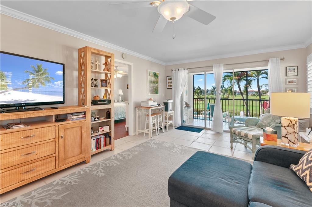 37 High Point Circle East, Unit 210 Naples, FL 34103 - Photo 8 of 29 a living room with furniture and a flat screen tv
