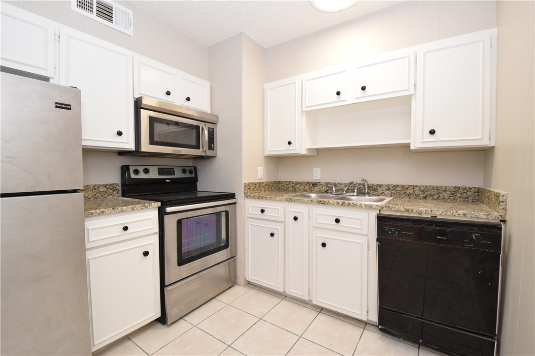 2404 Longview Street, Unit 103 Austin, TX 78705 - Photo 8 of 12 a kitchen with cabinets stainless steel appliances and sink