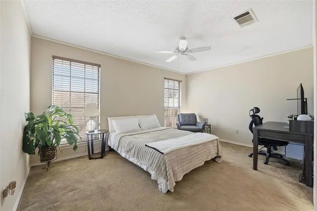 a bedroom with a bed table chair and a window