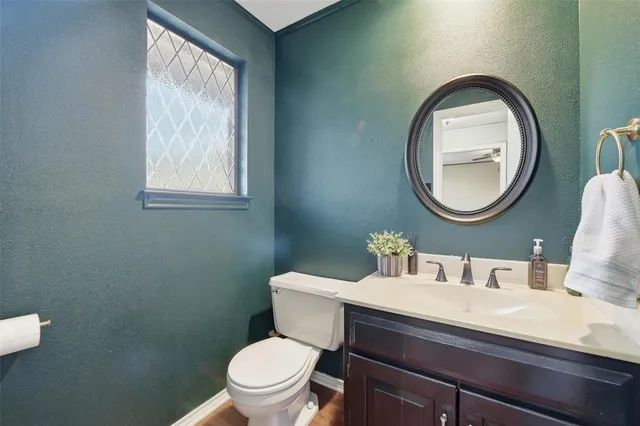 a bathroom with a toilet a sink and mirror