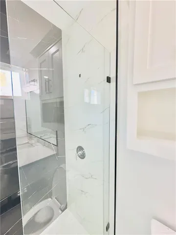 a bathroom with a shower and mirror