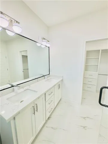 a bathroom with a double vanity sink a mirror and a shower