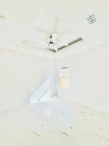 an empty room with white walls fan