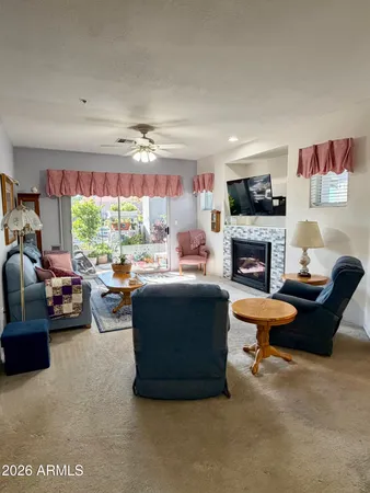 a living room with furniture fireplace and a large window