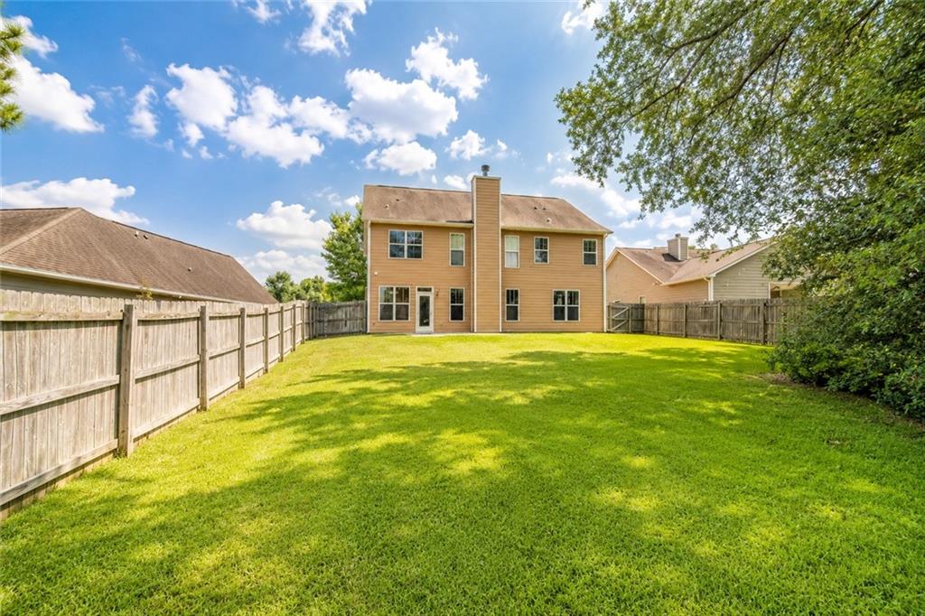 2078 Autumn Ridge Way Auburn, AL 36879 - Photo 24 of 24 Expansive grassy backyard featuring a full perimeter wooden fence and a two-story residence with a brick facade