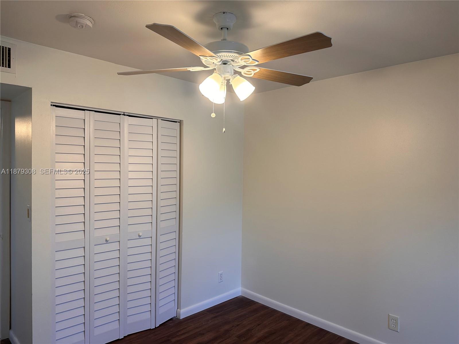 19700 Southwest 103rd Court, Unit 201 Cutler Bay, FL 33157 - Photo 15 of 21 a view of a small space with wooden floor and a ceiling fan