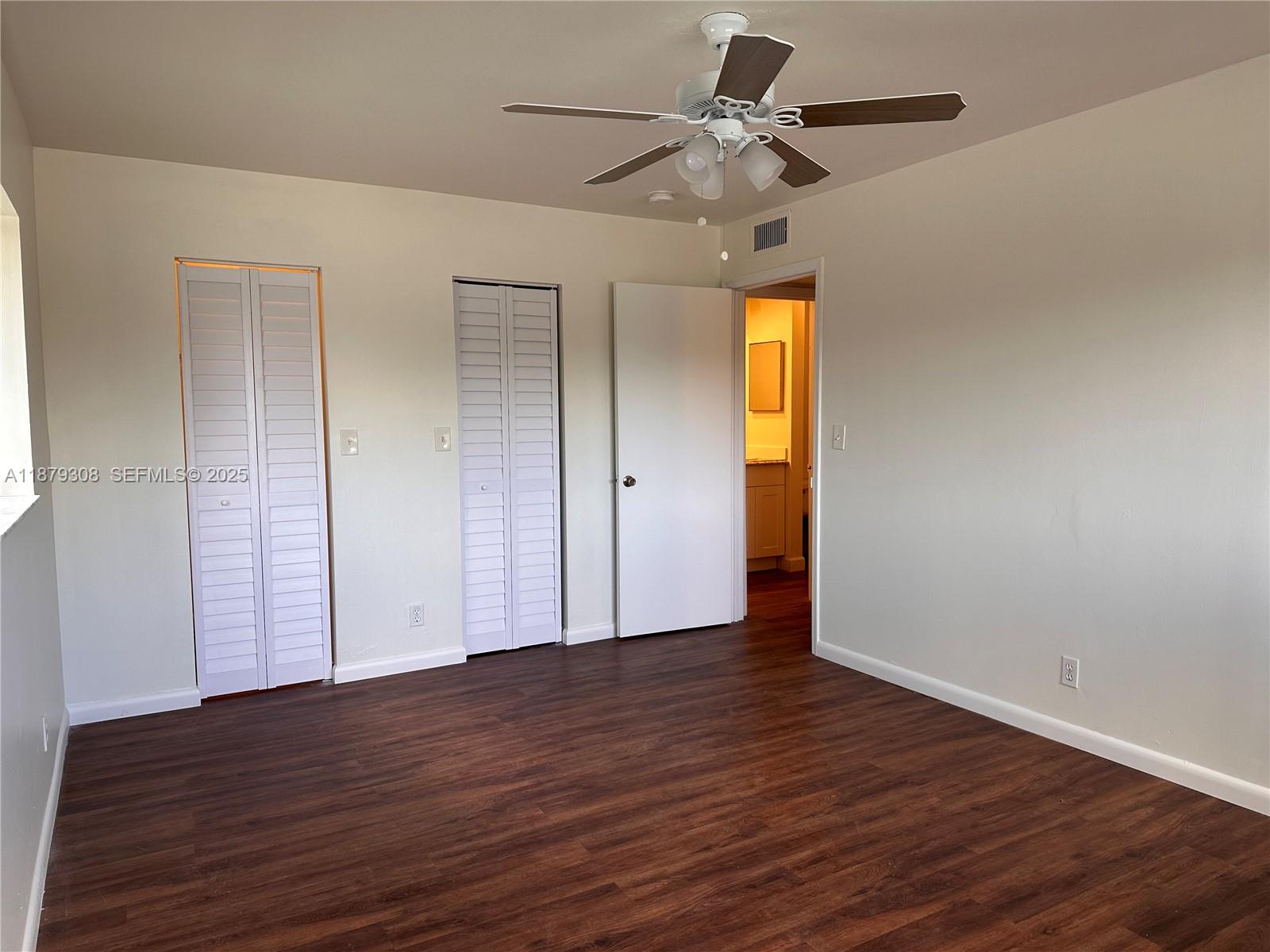 19700 Southwest 103rd Court, Unit 201 Cutler Bay, FL 33157 - Photo 9 of 21 an empty room with wooden floor closet and windows