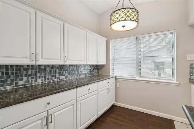 a kitchen with a white cabinets and chandelier