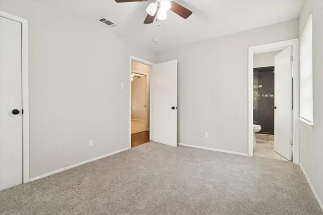an empty room with a ceiling fan and a window