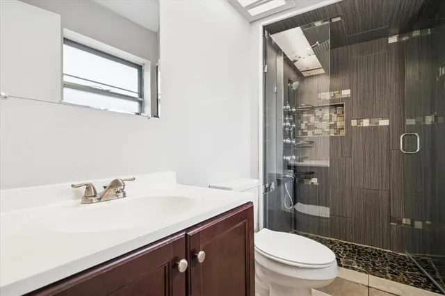 a bathroom with a sink a toilet and shower