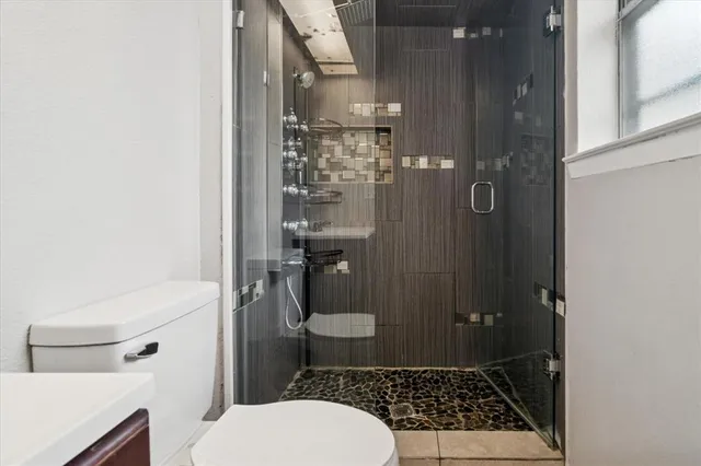 a bathroom with a toilet and a shower