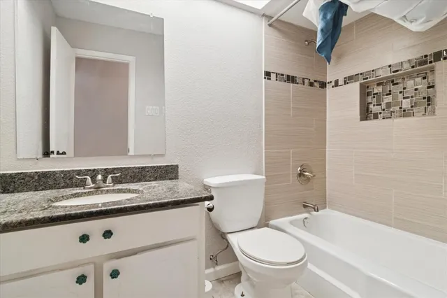a bathroom with a granite countertop sink toilet and shower