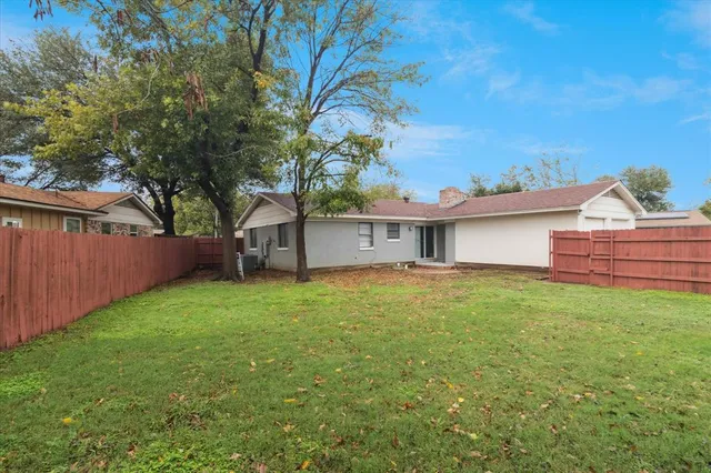 a backyard of a house with table and chairs