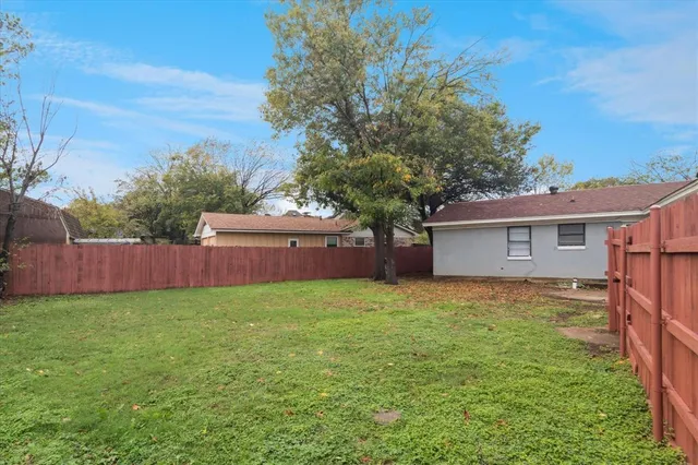 a view of a yard in front of a house with large tree