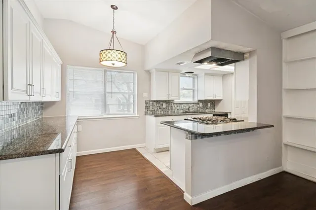 a kitchen with a stove window and cabinets