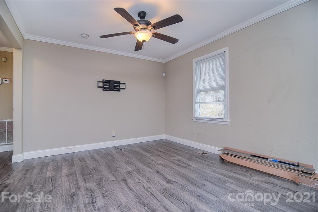 1100 Culp Street Lancaster, SC 29720 - Photo 7 of 30 an empty room with wooden floor and a ceiling fan