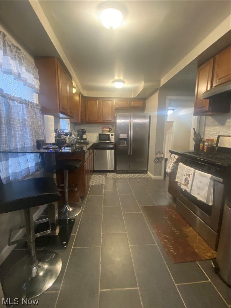 1500 Edgefield Road Lyndhurst, OH 44124 - Photo 5 of 24 Kitchen featuring sink, dark tile floors, stove, stainless steel refrigerator, and dishwashing machine