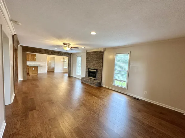 an empty room with wooden floor and fireplace