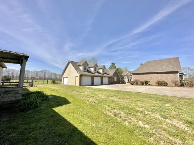 a view of a house with a big yard and a large tree