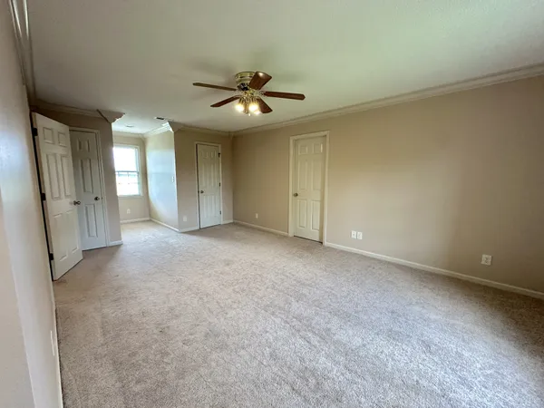 an empty room with a ceiling fan and a window