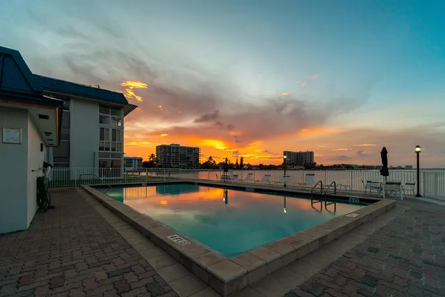 a view of swimming pool with outdoor seating and lake view