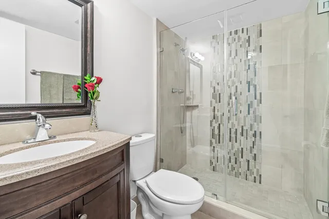 a bathroom with a sink a toilet and shower