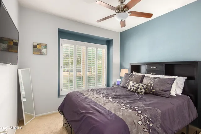 a large bed sitting in a bedroom next to a window